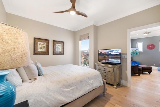 bedroom with ceiling fan, ornamental molding, and light hardwood / wood-style flooring