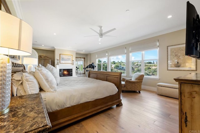 bedroom with ceiling fan, ornamental molding, and light hardwood / wood-style flooring