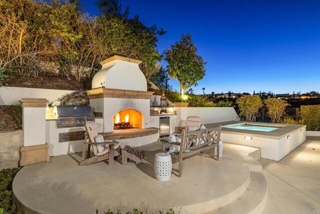 view of patio with grilling area, an outdoor fireplace, and area for grilling