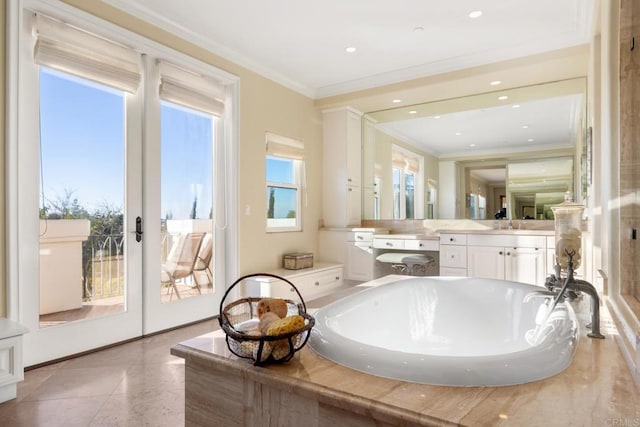 bathroom with plenty of natural light, vanity, ornamental molding, and a bathing tub