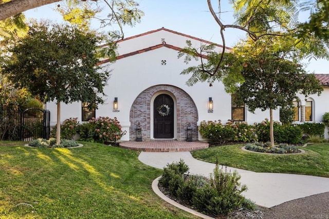 mediterranean / spanish-style house with a front yard