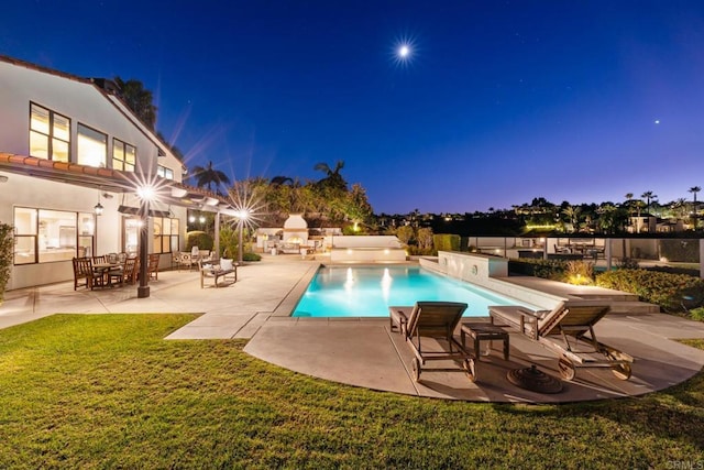 pool at dusk with a lawn and a patio