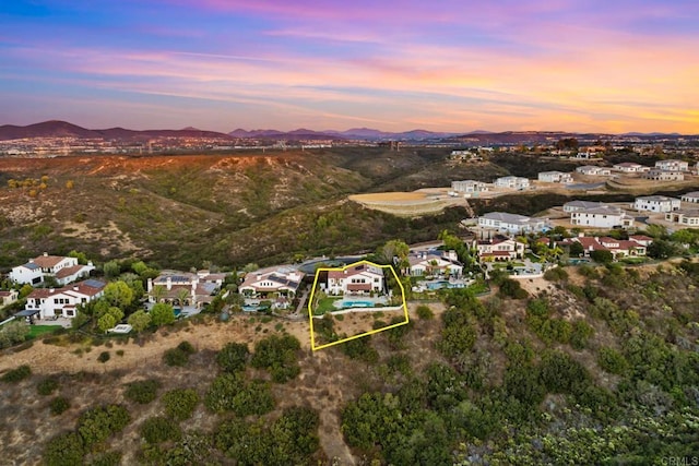 aerial view at dusk featuring a mountain view