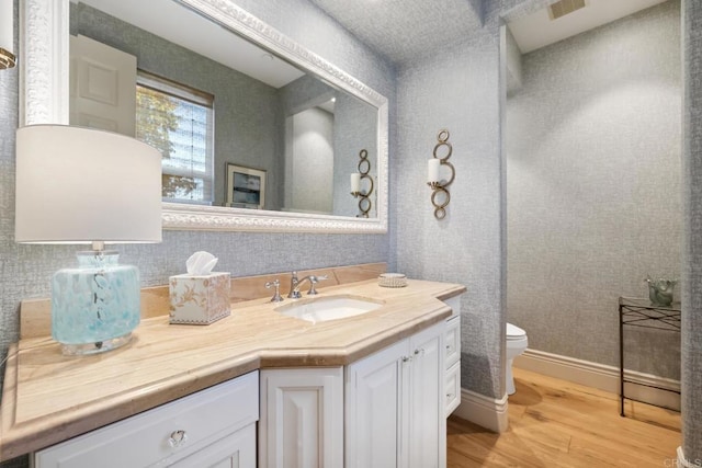 bathroom featuring toilet, hardwood / wood-style flooring, and vanity