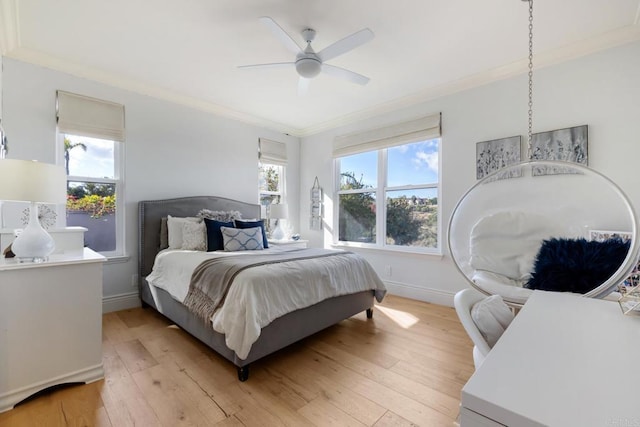 bedroom featuring ceiling fan, crown molding, and light hardwood / wood-style flooring