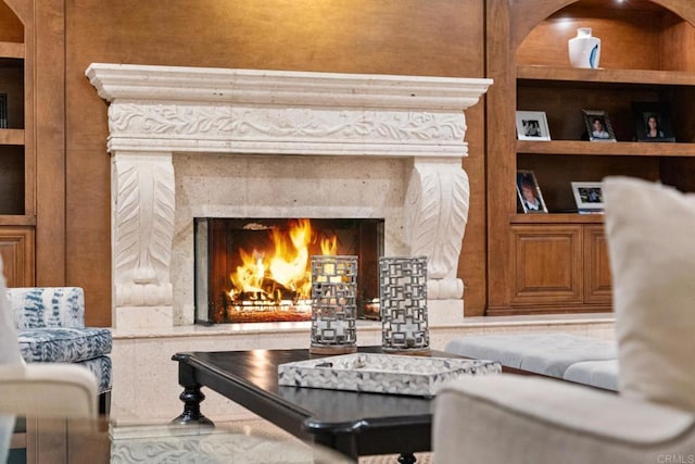 living area featuring built in features and a fireplace