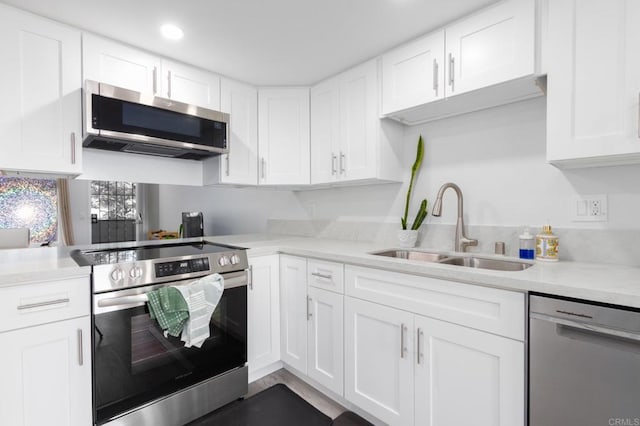 kitchen featuring appliances with stainless steel finishes, white cabinetry, and sink