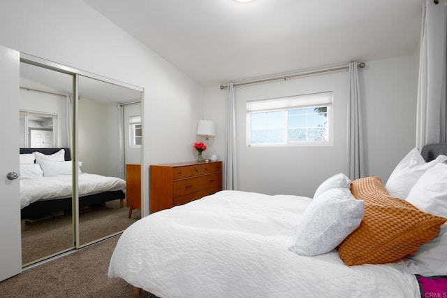 carpeted bedroom with lofted ceiling and a closet