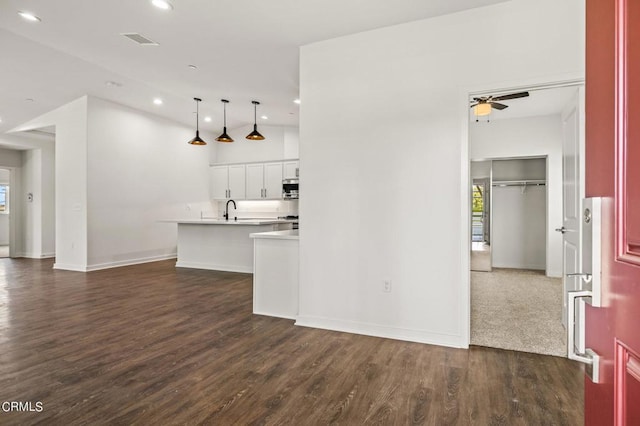 kitchen with ceiling fan, dark hardwood / wood-style flooring, white cabinets, and hanging light fixtures