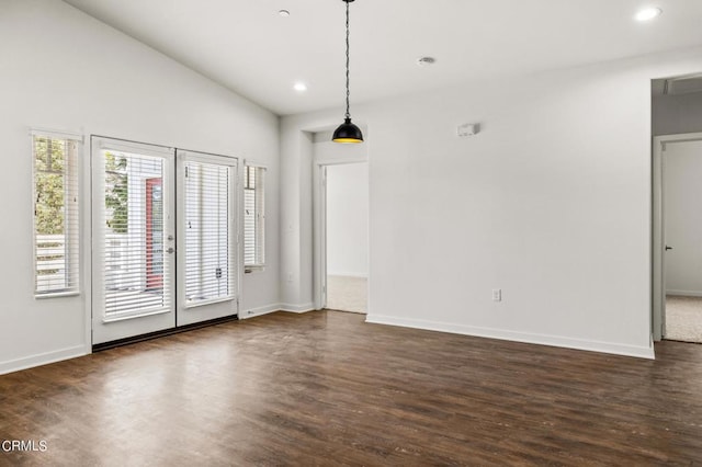 spare room featuring lofted ceiling and dark hardwood / wood-style floors