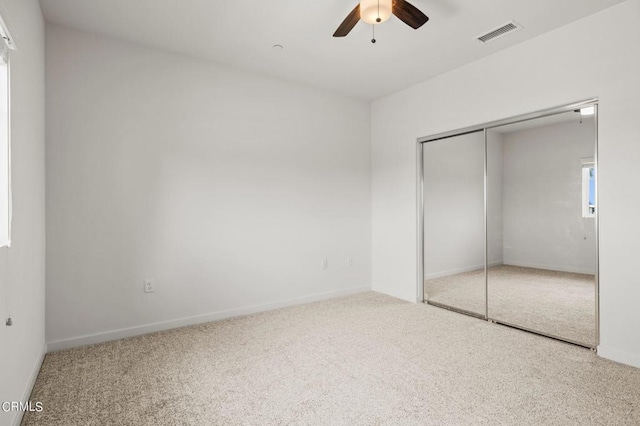 unfurnished bedroom with ceiling fan, carpet, and a closet