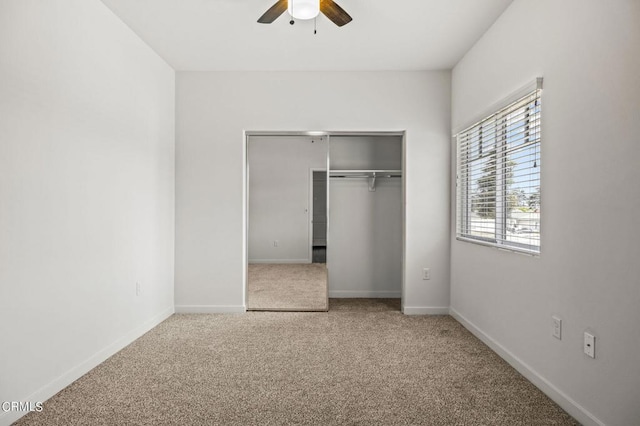 unfurnished bedroom with ceiling fan, carpet, and a closet