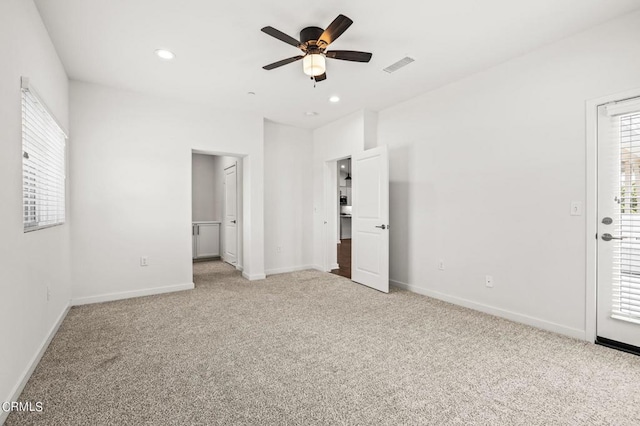 unfurnished bedroom with light carpet, ceiling fan, and multiple windows