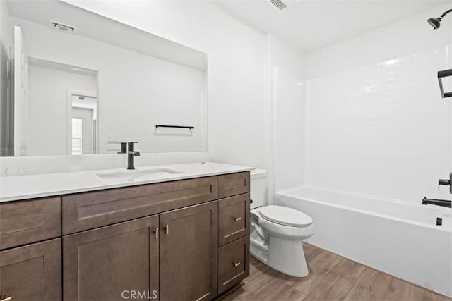 full bathroom featuring hardwood / wood-style flooring, bathtub / shower combination, toilet, and vanity