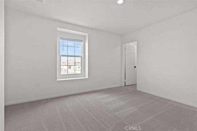 spare room featuring light colored carpet