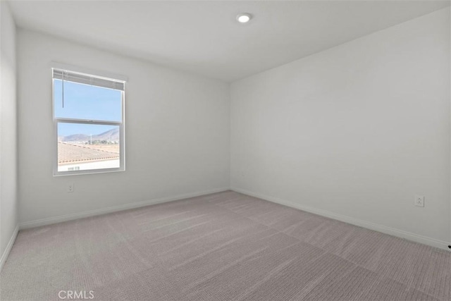 spare room featuring light colored carpet