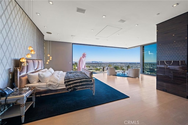 bedroom with hardwood / wood-style floors and floor to ceiling windows