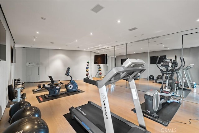 workout area with light hardwood / wood-style floors