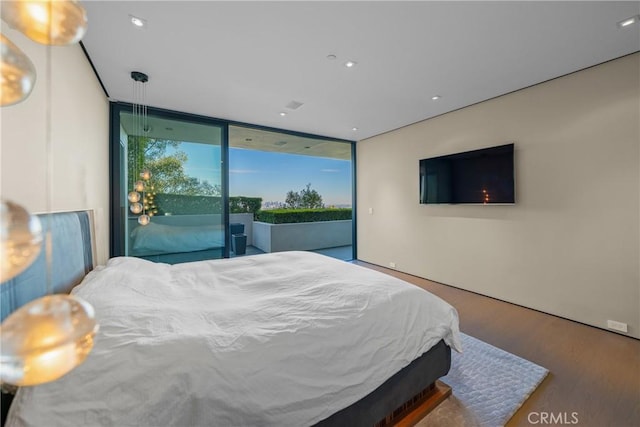 bedroom featuring access to outside, floor to ceiling windows, and hardwood / wood-style flooring