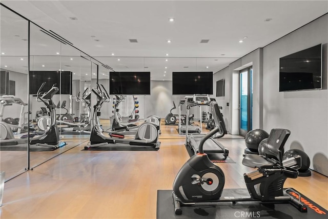 workout area with light hardwood / wood-style flooring