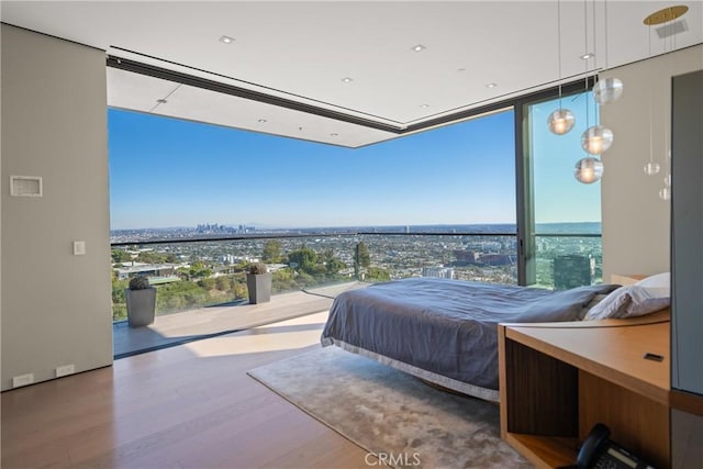 bedroom with floor to ceiling windows and hardwood / wood-style floors