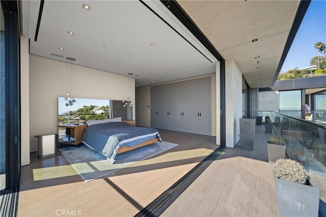 bedroom with dark hardwood / wood-style floors and multiple windows