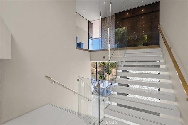 stairs featuring a towering ceiling and tile patterned floors