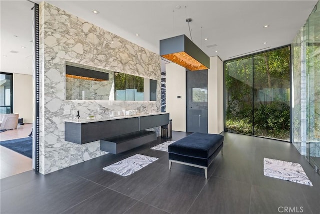 bathroom featuring a wealth of natural light, tile patterned flooring, vanity, and a wall of windows