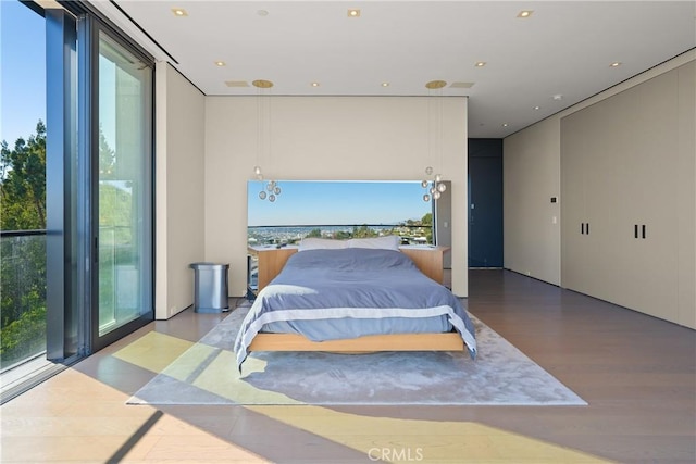 bedroom with expansive windows and light wood-type flooring