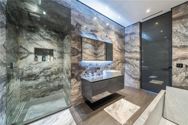 bathroom featuring tile patterned flooring, tile walls, and tiled shower