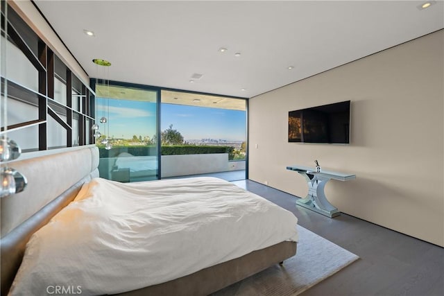 bedroom featuring expansive windows, access to exterior, and wood-type flooring