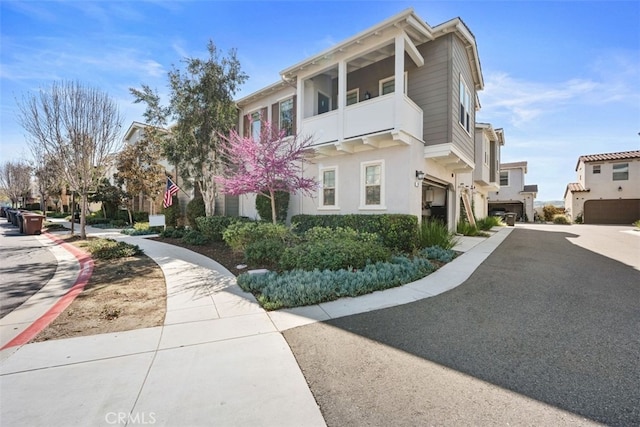 20 Jaripol Cir, Rancho Mission Viejo, CA 92694 - view of front of house featuring a balcony, driveway, an attached garage, stucco siding, and a residential view