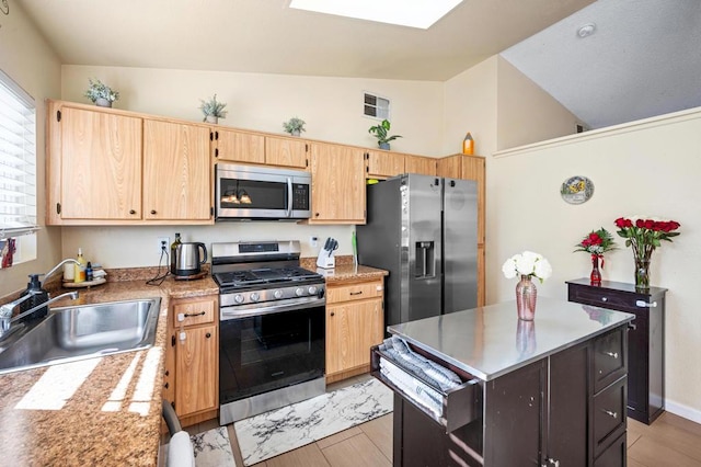 kitchen with sink, a kitchen island, stainless steel appliances, and lofted ceiling