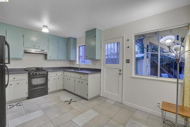 kitchen featuring sink, light tile patterned flooring, and black appliances