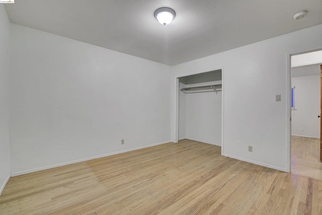 unfurnished bedroom with a closet and light hardwood / wood-style flooring