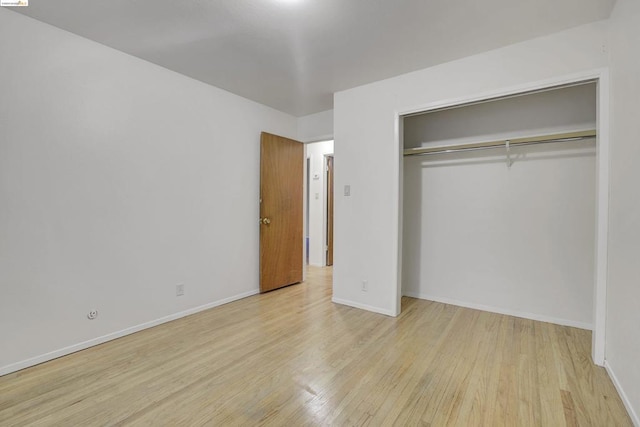 unfurnished bedroom with a closet and light hardwood / wood-style flooring