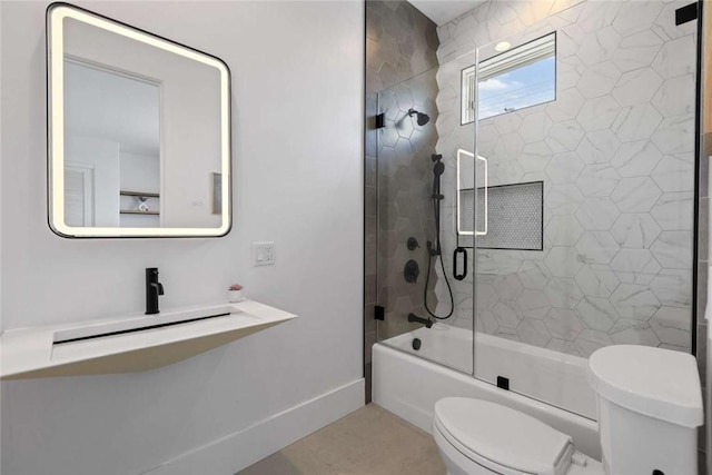 full bathroom with sink, combined bath / shower with glass door, and toilet