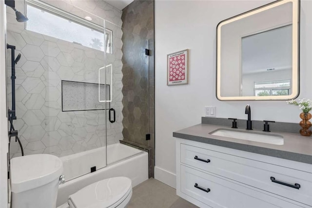 full bathroom with enclosed tub / shower combo, vanity, and toilet