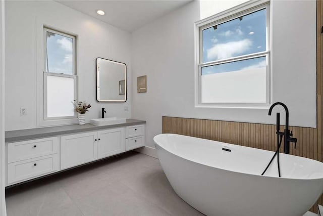 bathroom featuring vanity, tile patterned flooring, and a bathtub