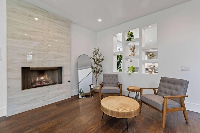 sitting room with a premium fireplace and dark hardwood / wood-style flooring