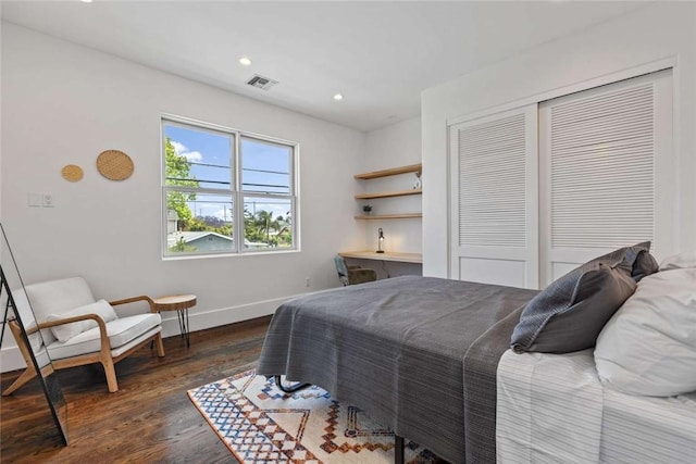 bedroom with dark wood-type flooring and a closet