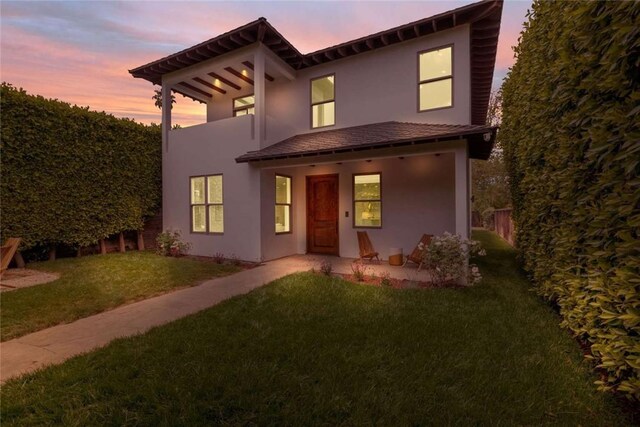 view of front of home with a yard and a patio area