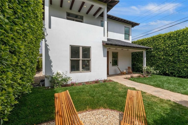 rear view of house featuring a yard