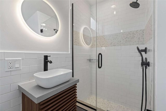 bathroom with vanity, tile walls, and an enclosed shower