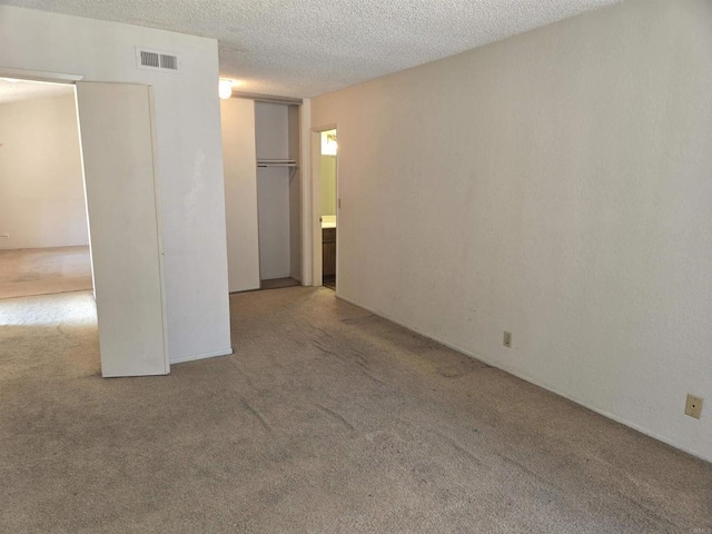 carpeted spare room with a textured ceiling