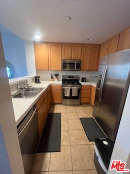 kitchen featuring sink, light tile patterned floors, and stainless steel appliances