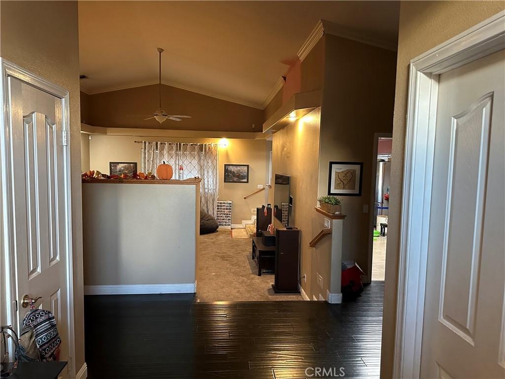 interior space featuring plenty of natural light, wood-type flooring, vaulted ceiling, and ornamental molding