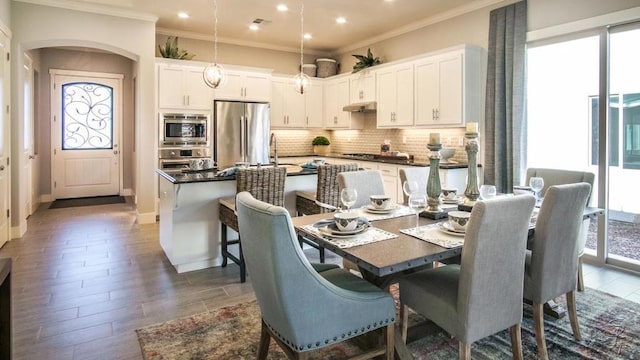 dining area featuring crown molding and dark hardwood / wood-style flooring