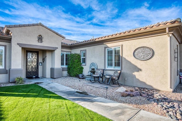 property entrance with a lawn