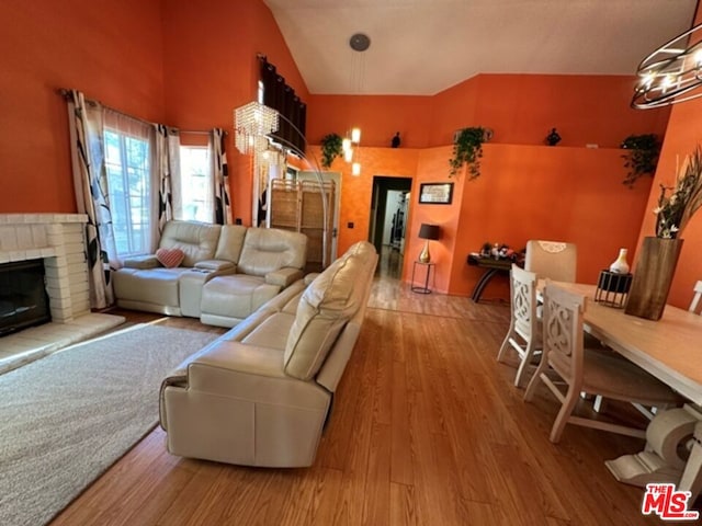 living room featuring wood-type flooring, a fireplace, and vaulted ceiling